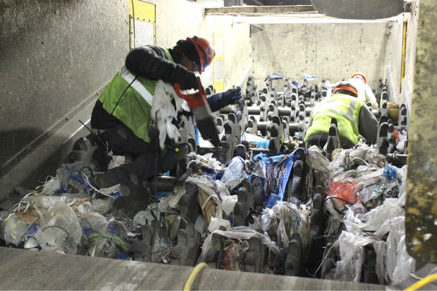 Workers clearing plastic bags in MRF; photo credit DNAinfo Patty Welti